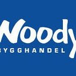 Vit text mot blå bakgrund visar logotypen "Woody Bygghandel", med "Woody" i ett stort lekfullt typsnitt och "BYGGHANDEL" i mindre versaler under det.